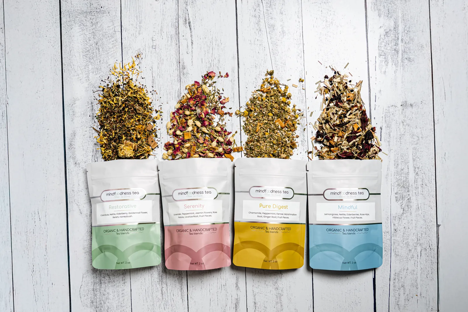 Four Mindfoodness pouches with whole loose herbs spilling out above them Four Mindfoodness pouches with whole loose herbs spilling out above them